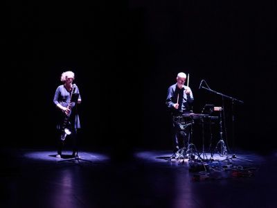 The four members of the Plus Minus Ensemble performing against black background